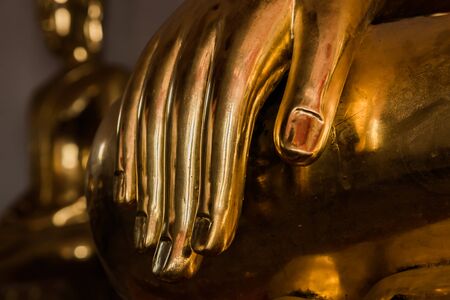 close up of Buddha statue focus at hand low keyの写真素材