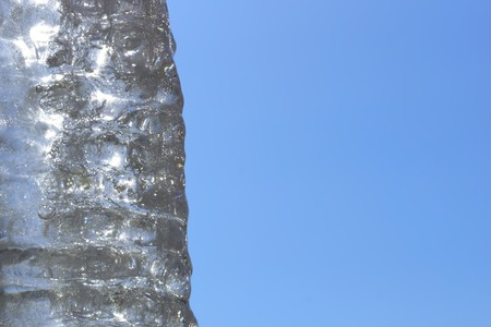 icicle. a fragment of a huge icicle of ice against the blue sky