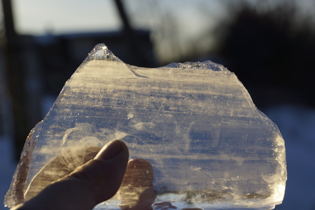 icicle in his hands. shines on the sun. ice floe melts from the sunの写真素材