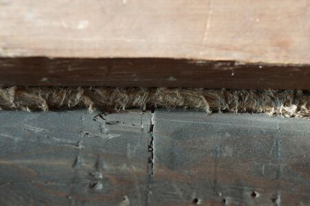 wooden beam. old house. the cracks are covered with tow. as built in the early 20th century.