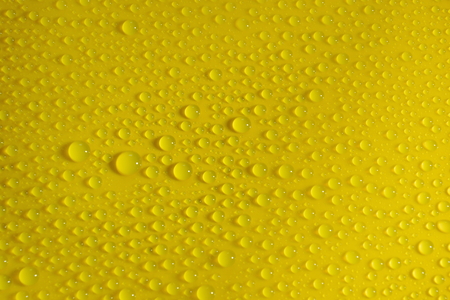 natural water drops on yellow background textureの写真素材