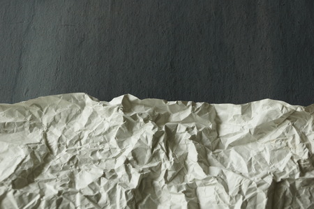 sheet of white crumpled paper on gray background texture backgroundの写真素材