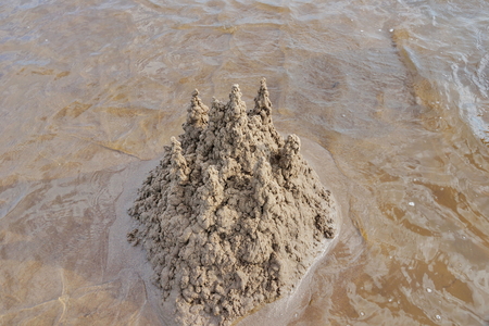 sand castle on the beach against the water summer dayの写真素材