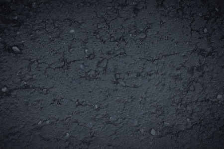 the dark gray asphalt texture background rocks interspersed with gravel old crackの写真素材