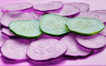 Cucumber slices texture background. fresh cucumbers diet dish. pink backgroundの写真素材