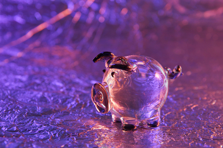 glass pig on a metal background purple pink pig year close-upの写真素材