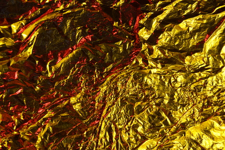 abstract background texture metal aluminum foil gold yellow and red colorsの写真素材