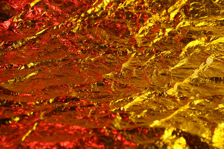abstract background texture metal aluminum foil gold yellow and red colorsの写真素材
