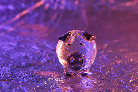 glass pig on a metal background purple pink pig year close-upの写真素材