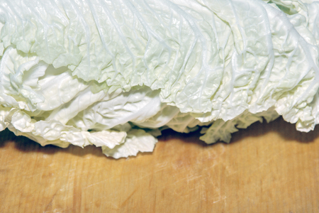 Peking cabbage, or Chinese cabbage, or petsai, or lettuce on a brown chopping Boardの写真素材