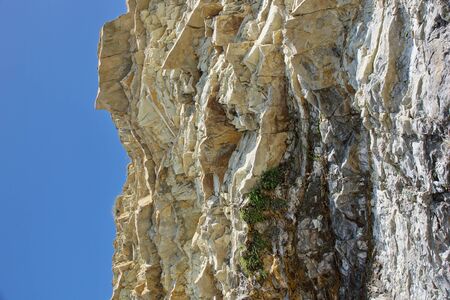 piece of rock and blue sky. Sunny day, blue sky. Stone background.