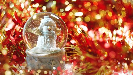 snowman in a ball snow abstract background natural festive red gold bokeh sequins tinselの写真素材