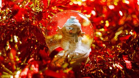 snowman in a ball snow abstract background natural festive red gold bokeh sequins tinselの写真素材