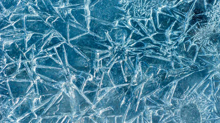 Beautiful ice texture with cracks of a frozen puddle on the asphalt for 3d texturing or design....