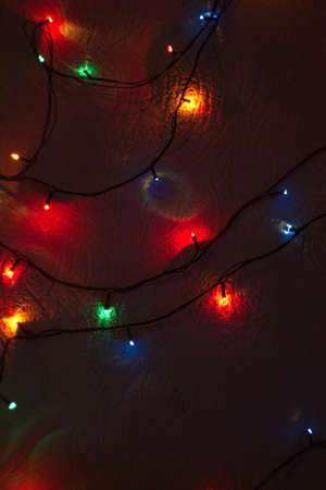 christmas garlands of lights on the wall in the house dark background overlay