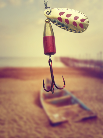 Red and gold fishing hook. Near the lake, vintage colors.の写真素材