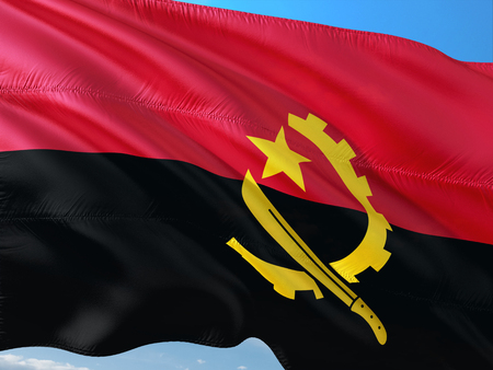 Flag of Angola waving in the wind against deep blue sky. High quality fabric.の写真素材