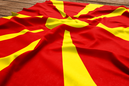 Flag of Macedonia on a wooden desk background. Silk Macedonian flag top view.の写真素材