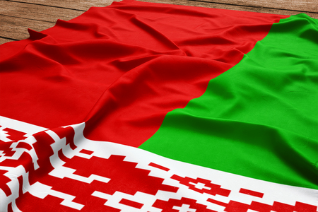 Flag of Belarus on a wooden desk background. Silk Belarusian flag top view.の写真素材