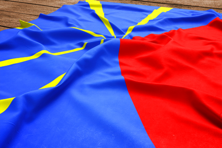Flag of Reunion on a wooden desk background. Silk flag top view.の写真素材