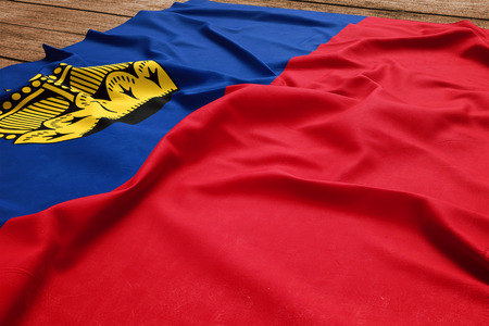 Flag of Liechtenstein on a wooden desk background. Silk Liechtensteiner flag top view.の写真素材