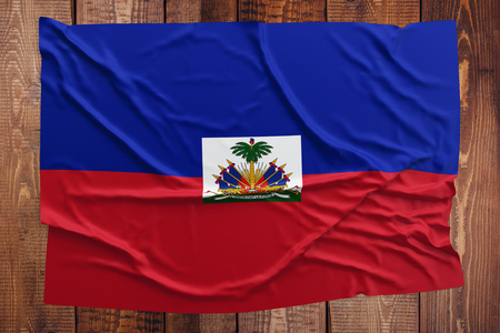 Flag of Haiti on a wooden table background. Wrinkled Haitian flag top view.の写真素材
