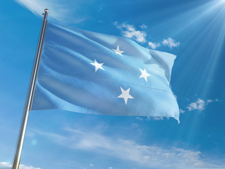 Micronesia National Flag Waving on pole against sunny blue sky background. High Definitionの写真素材