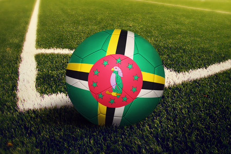 Dominica ball on corner kick position, soccer field background. National football theme on green grass.の写真素材