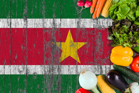 Fresh vegetables from Suriname on table. Cooking concept on wooden flag background.の写真素材