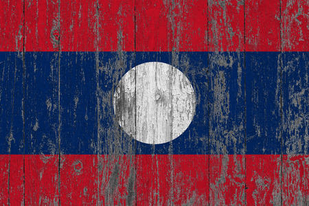 Flag of Laos painted on worn out wooden texture background.の写真素材