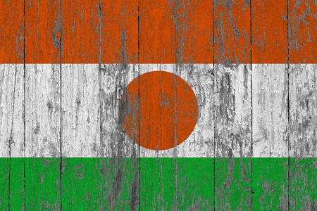 Flag of Niger painted on worn out wooden texture background.の写真素材