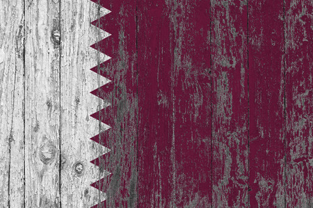 Flag of Qatar painted on worn out wooden texture background.の写真素材