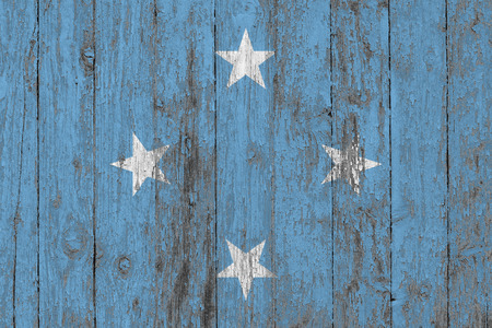 Flag of Micronesia painted on worn out wooden texture background.の写真素材