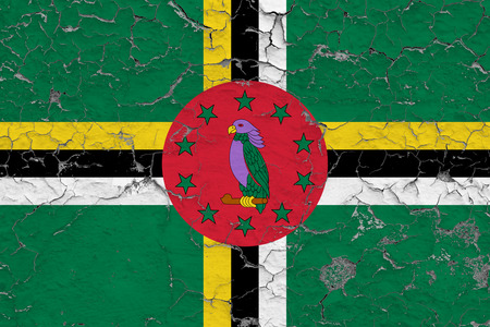 Flag of Dominica painted on cracked dirty wall. National pattern on vintage style surface.の写真素材