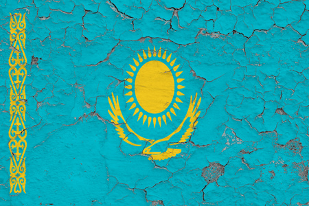 Flag of Kazakhstan painted on cracked dirty wall. National pattern on vintage style surface.の写真素材