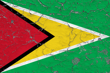 Flag of Guyana painted on cracked dirty wall. National pattern on vintage style surface.の写真素材