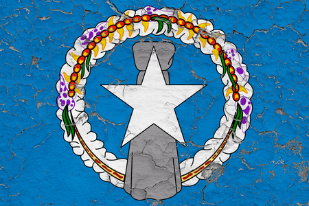 Flag of Northern Mariana Islands painted on cracked dirty wall. National pattern on vintage style surface.の写真素材