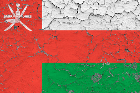 Flag of Oman painted on cracked dirty wall. National pattern on vintage style surface.の写真素材