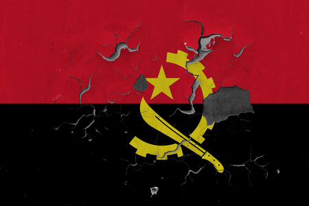 Close up grungy, damaged and weathered Angola flag on wall peeling off paint to see inside surface.の写真素材