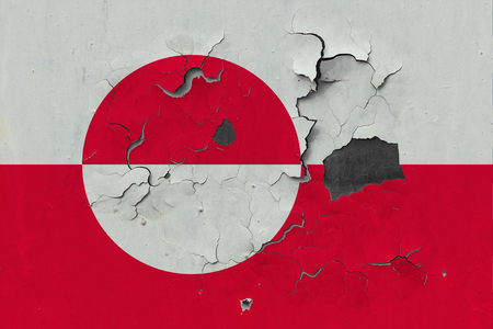 Close up grungy, damaged and weathered Greenland flag on wall peeling off paint to see inside surface.の写真素材