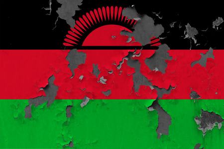 Close up grungy, damaged and weathered Malawi flag on wall peeling off paint to see inside surface.の写真素材