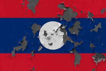 Close up grungy, damaged and weathered Laos flag on wall peeling off paint to see inside surface.の写真素材