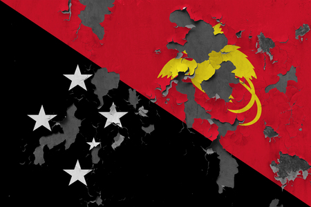 Close up grungy, damaged and weathered Papua New Guinea flag on wall peeling off paint to see inside surface.の写真素材