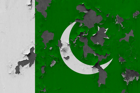 Close up grungy, damaged and weathered Pakistan flag on wall peeling off paint to see inside surface.の写真素材
