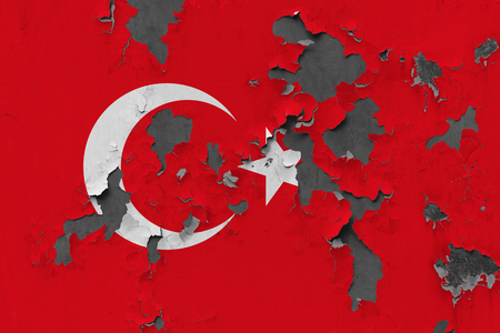 Close up grungy, damaged and weathered Turkey flag on wall peeling off paint to see inside surface.の写真素材