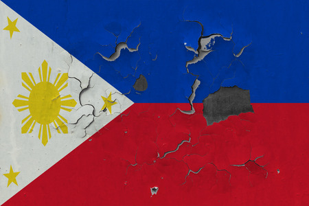 Close up grungy, damaged and weathered Philippines flag on wall peeling off paint to see inside surface.の写真素材