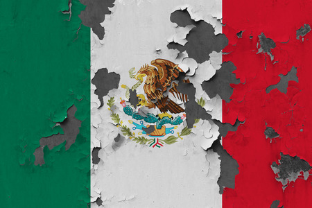 Close up grungy, damaged and weathered Mexico flag on wall peeling off paint to see inside surface.の写真素材