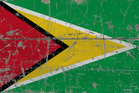 Grunge Guyana flag on old scratched wooden surface. National vintage background.の写真素材