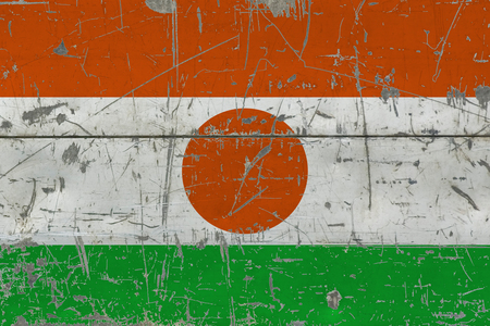 Grunge Niger flag on old scratched wooden surface. National vintage background.の写真素材