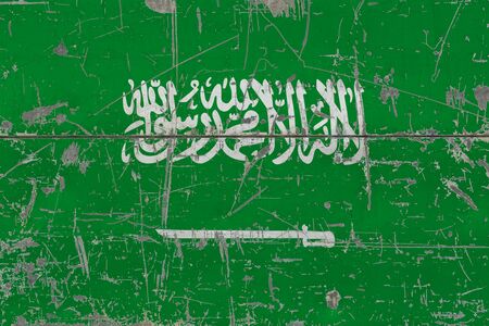Grunge Saudi Arabia flag on old scratched wooden surface. National vintage background.の写真素材